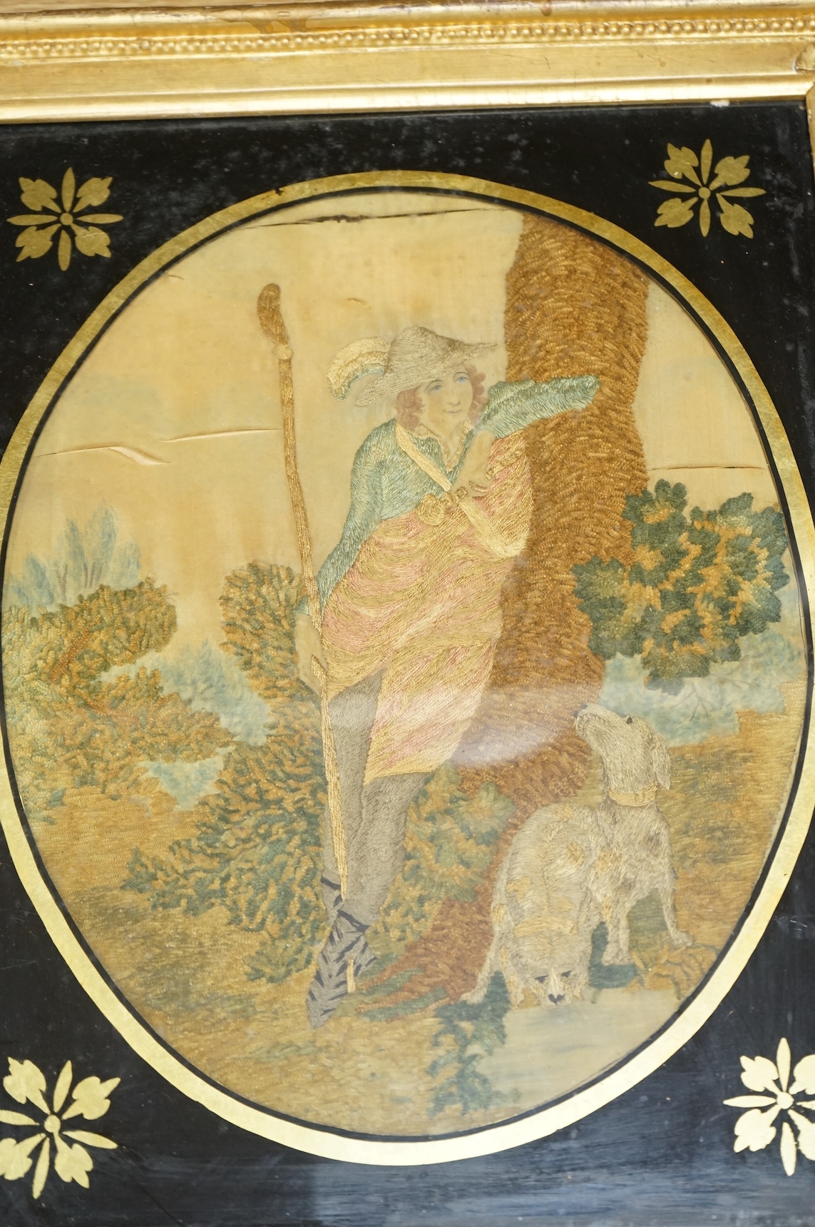 A pair of oval framed early 19th century silk embroideries of a Shepherd and Shepherdess mounted in Verre eglomise glass and gilt frames. Embroideries 28cm high